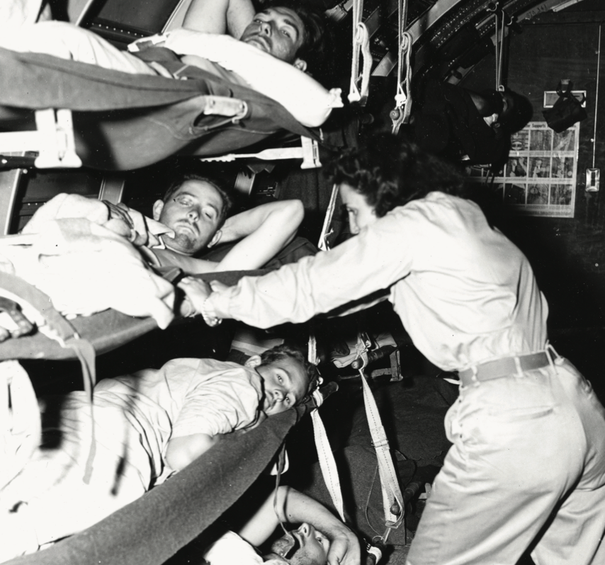 Flight Nurse Jo Nabors secures Okinawa casualty into stretcher on transport plane, which has been converted into hospital plane after bringingin mail and supplies, April 7, 1945 (National Archives and Records Administration/U.S. Army Signal Corps)